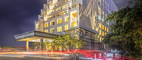 A modern hotel with a prominent sign reading "THE PARK." It features a multi-story structure with a flat roof and a covered entrance area.