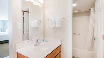 Un baño con lavabo, espejo y ducha.