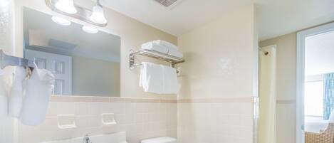 A bathroom with a white sink, a toilet, and a shower area.