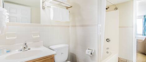 A bathroom with a sink, toilet, and shower.