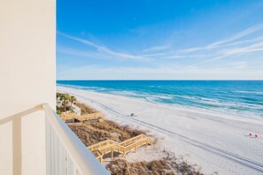 A beach view from a balcony with wooden walkways leading to the shore, clear skies, and calm ocean. - Beachside Resort Panama City Beach (Panama City Beach)