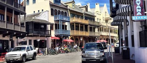 Calle con edificios históricos, un letrero que dice 'Havana Beach' y un SUV blanco estacionado en la calle adoquinada.