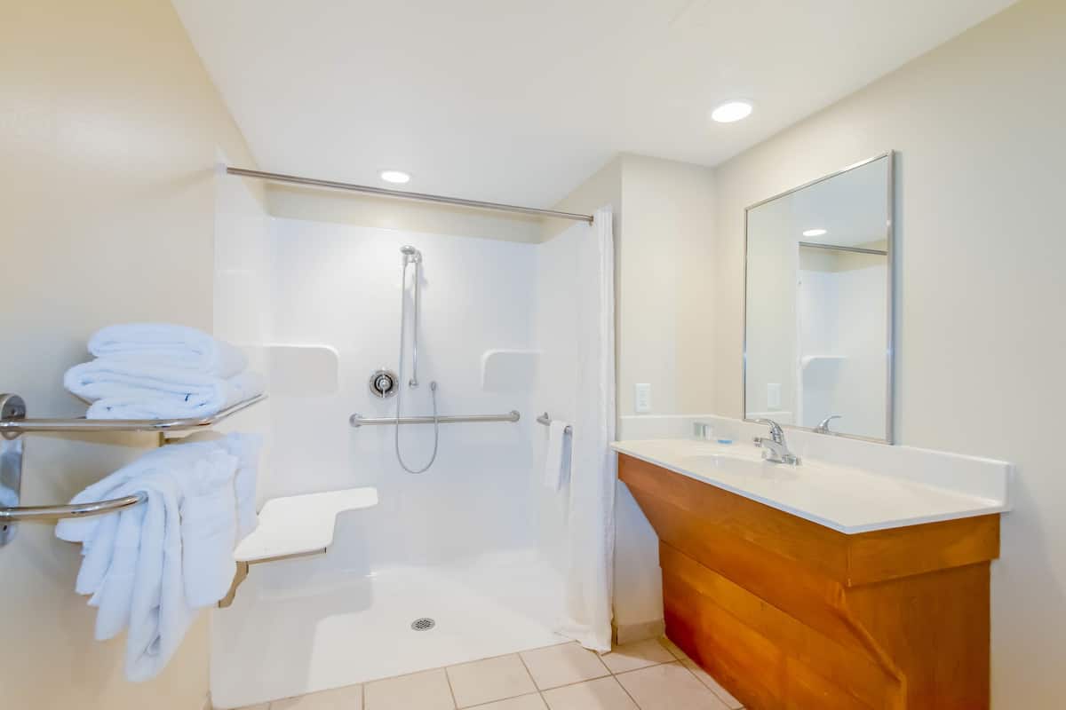 A modern bathroom with a shower, toilet, and vanity.