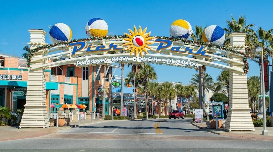 The entrance to Pier 70, featuring a sun and beach ball decoration, palm trees, and a clear blue sky.