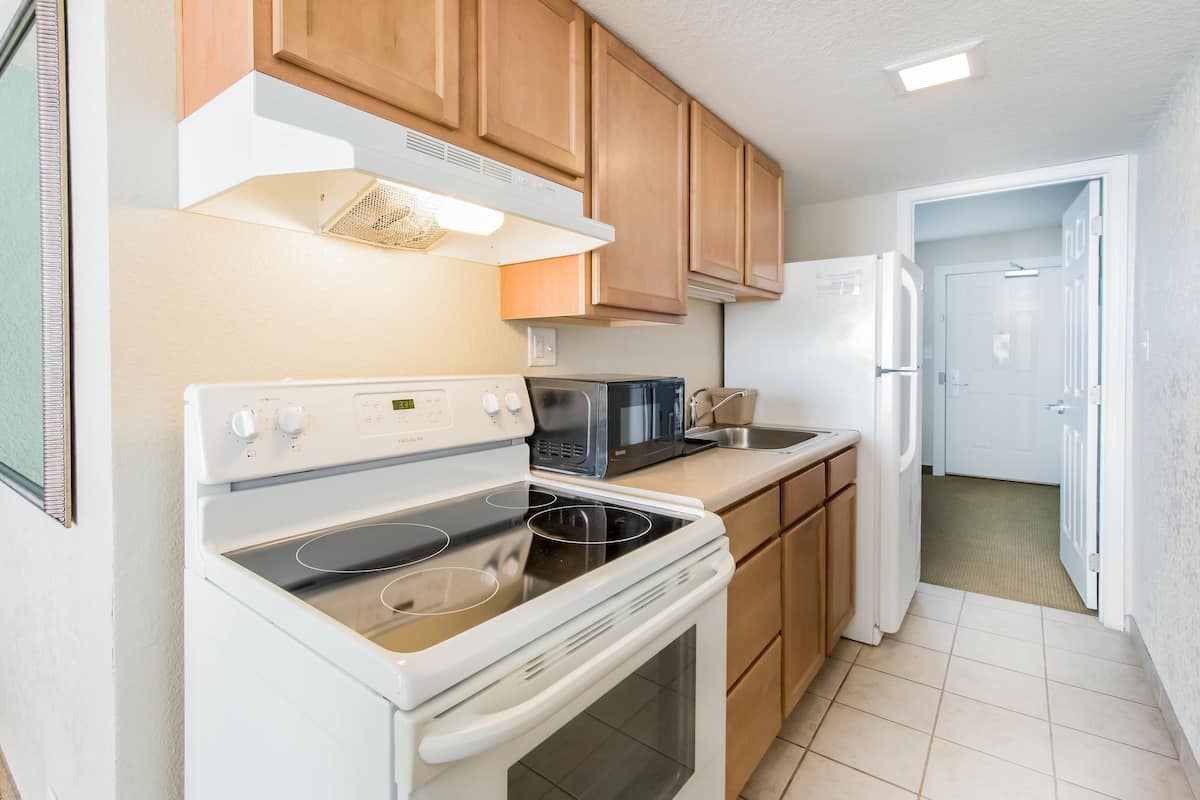 A compact kitchen with a stove, microwave, and refrigerator.