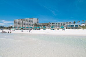 A beachfront hotel with multiple balconies, beach umbrellas, and a sandy beach. - Beachside Resort Panama City Beach (Panama City Beach)