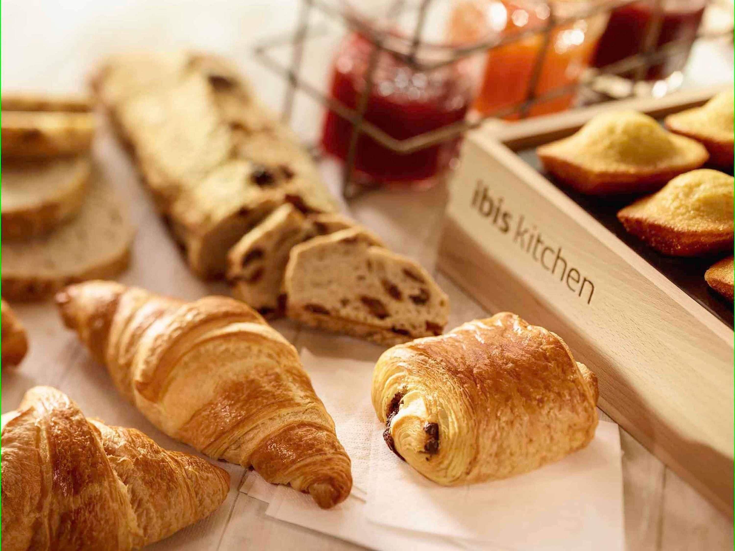 Une variété de produits de boulangerie, notamment des croissants et du pain, avec une étiquette indiquant « Cuisine ibis ».