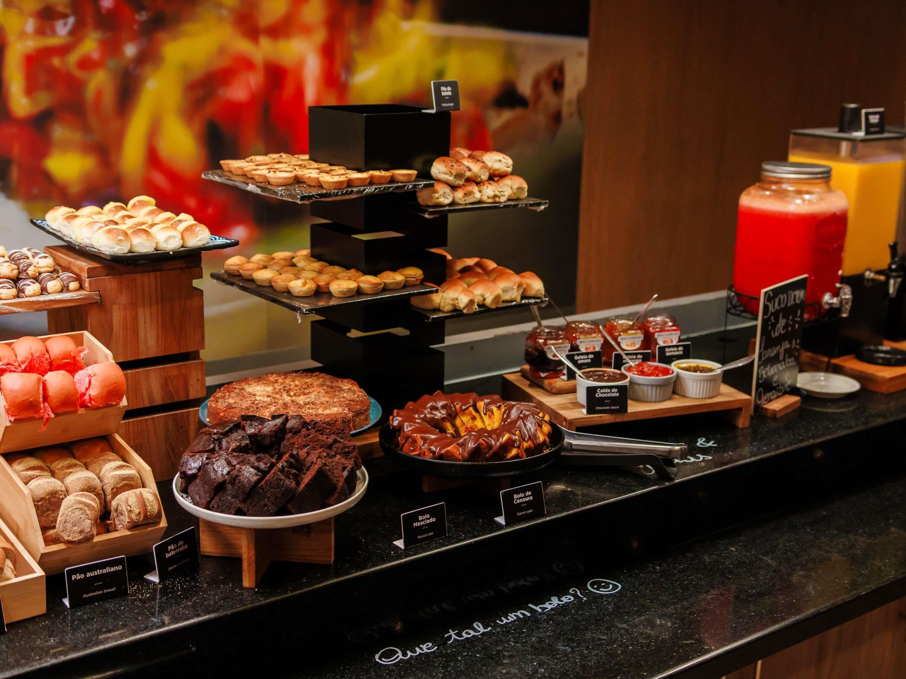 A buffet with various baked goods, including bread, pastries, and desserts.