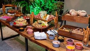 Una mesa de buffet con diversos alimentos, como quesos, carnes y frutas.