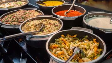 A buffet with various dishes including pasta, rice, and soups.