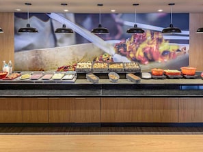 Enjoy a sumptuous spread at our buffet, featuring a variety of dishes and a vibrant mural backdrop.