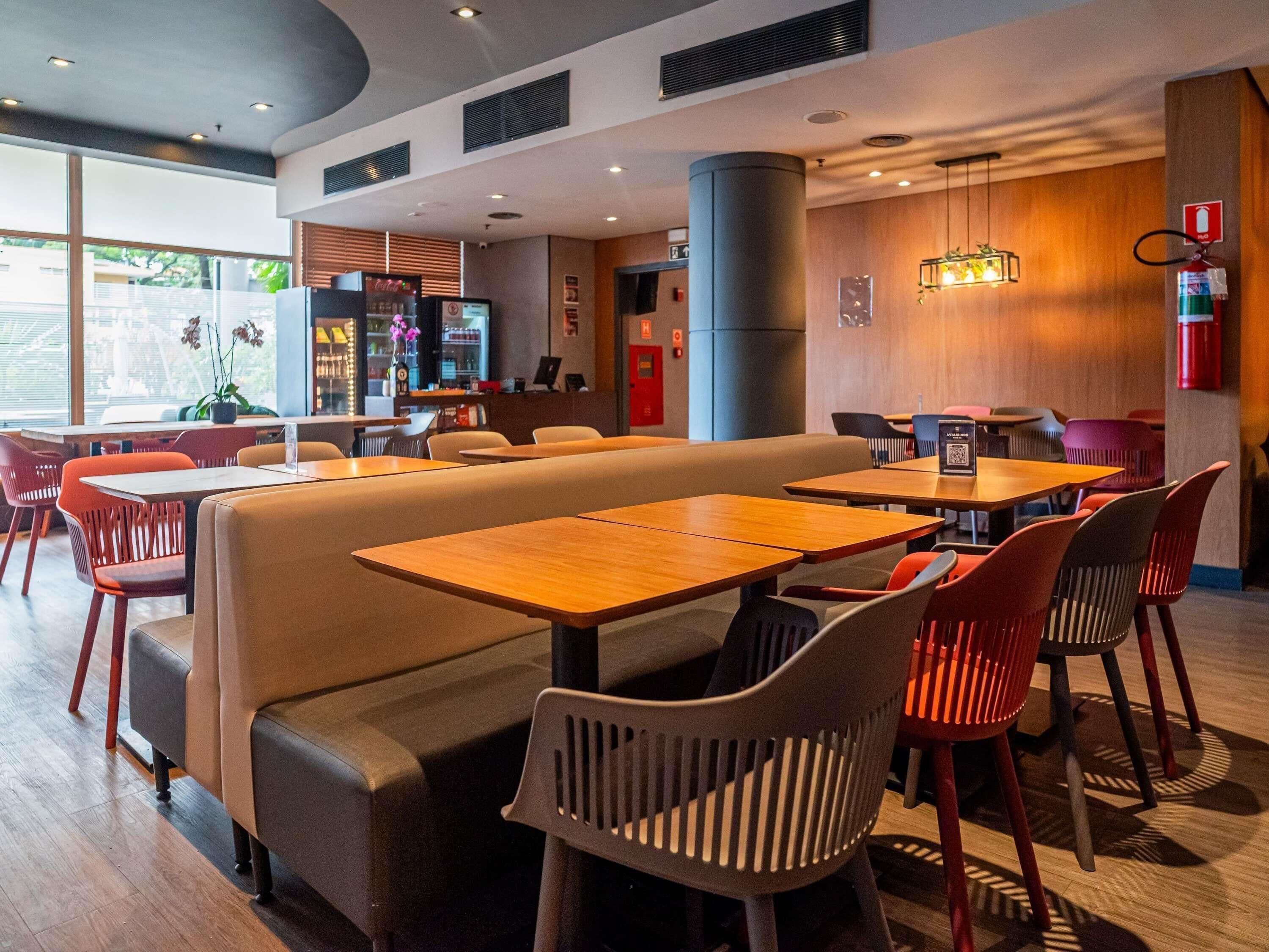 A modern restaurant interior with booths, tables, and a bar area.