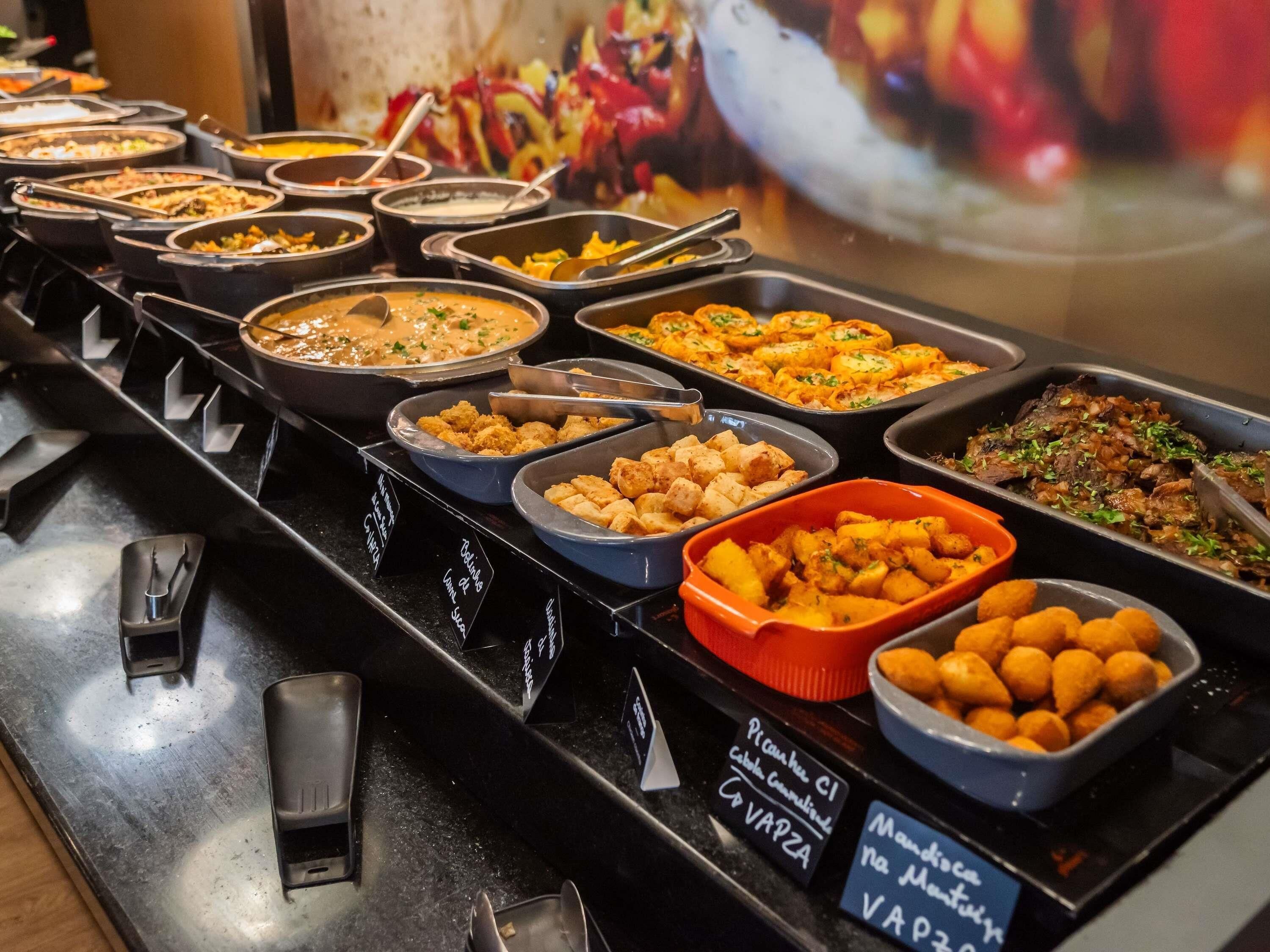 A buffet with various dishes and labeled containers.