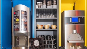Une machine à café, un distributeur de boissons et un présentoir de paquets de café.