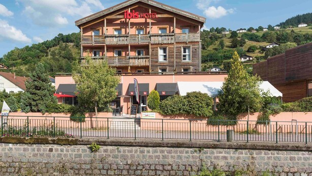 Un hôtel doté d’un balcon, d’une enseigne et offrant une vue sur le paysage environnant.