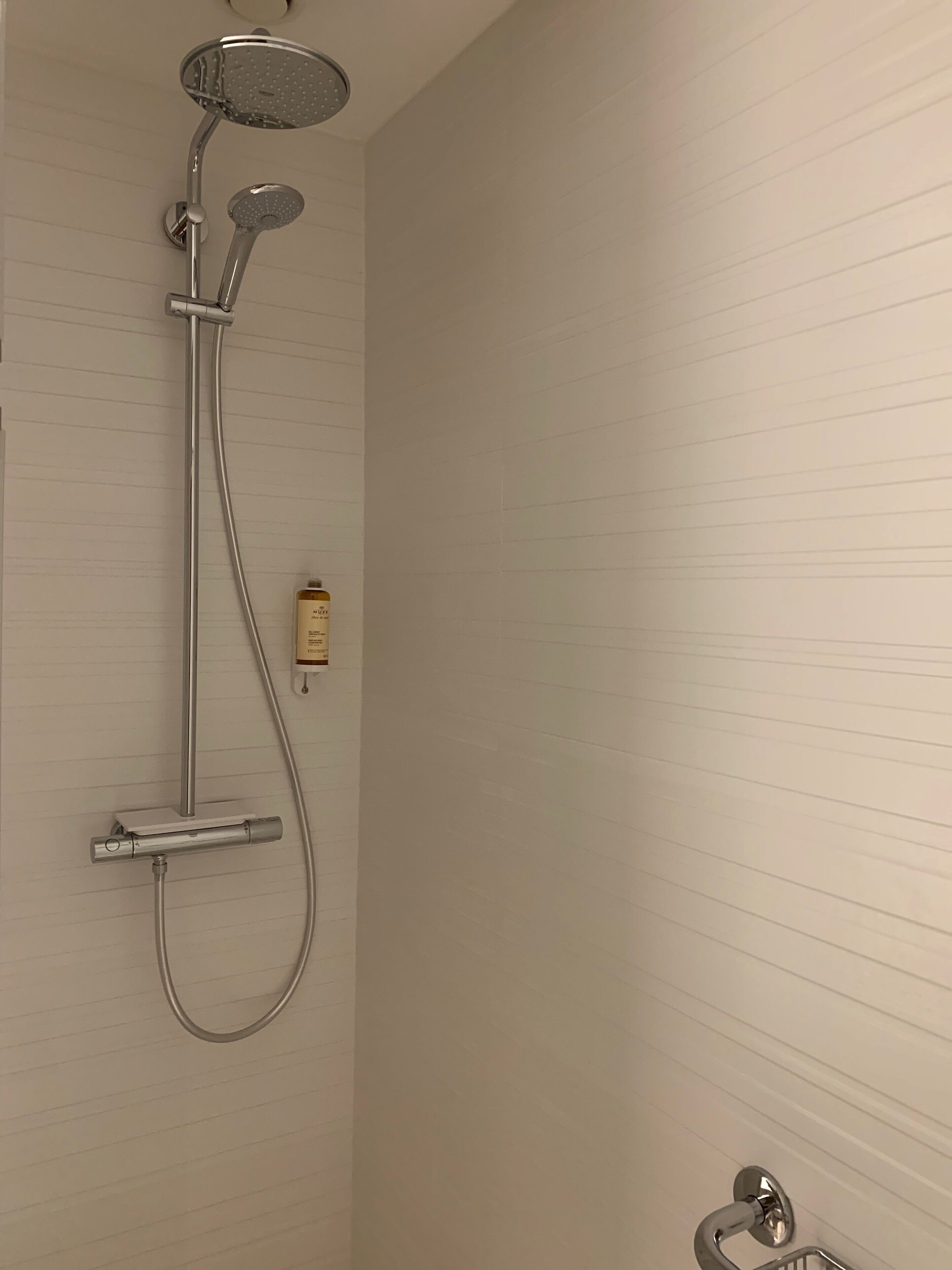 Ducha con cabezal de ducha de mano y grifo empotrado.