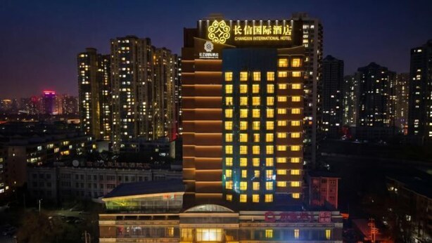 A high-rise hotel with multiple floors, illuminated windows, and a prominent signage at the top. - Changxin International Hotel (Lanzhou)