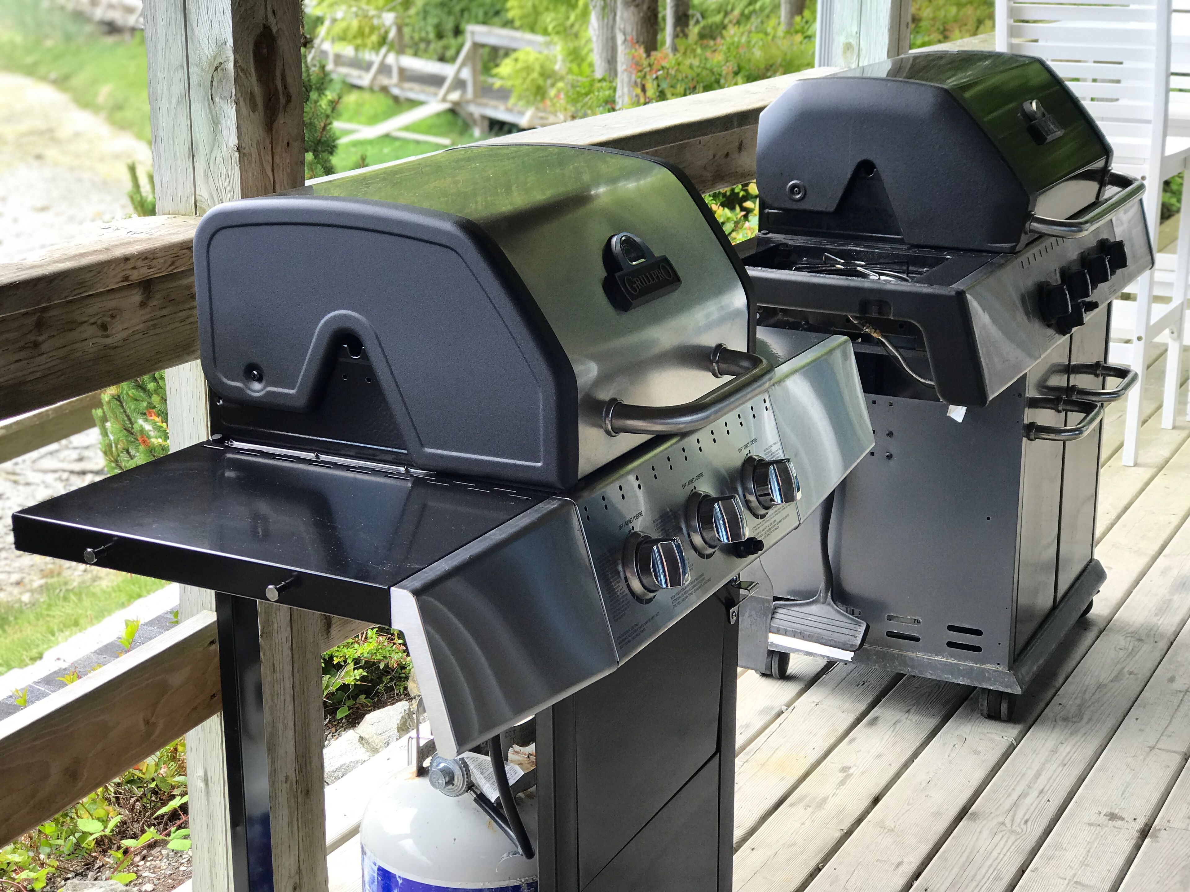 Un barbecue avec une table d’appoint et une bouteille de gaz.