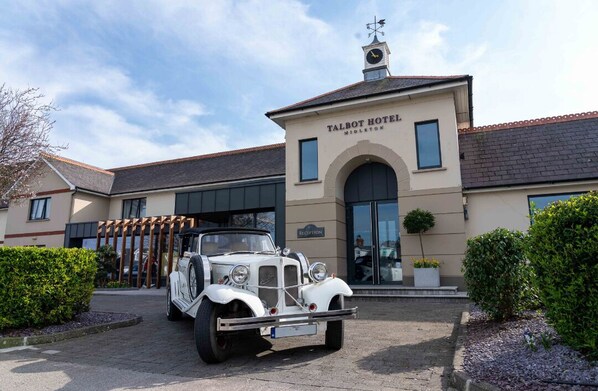 A Talbot Hotel with a classic car parked in front.