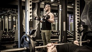 A gym with weightlifting equipment and a person performing a bench press. - Talbot Hotel Midleton (Midleton)