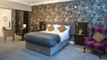 A bedroom with a bed, a chair, and a nightstand.