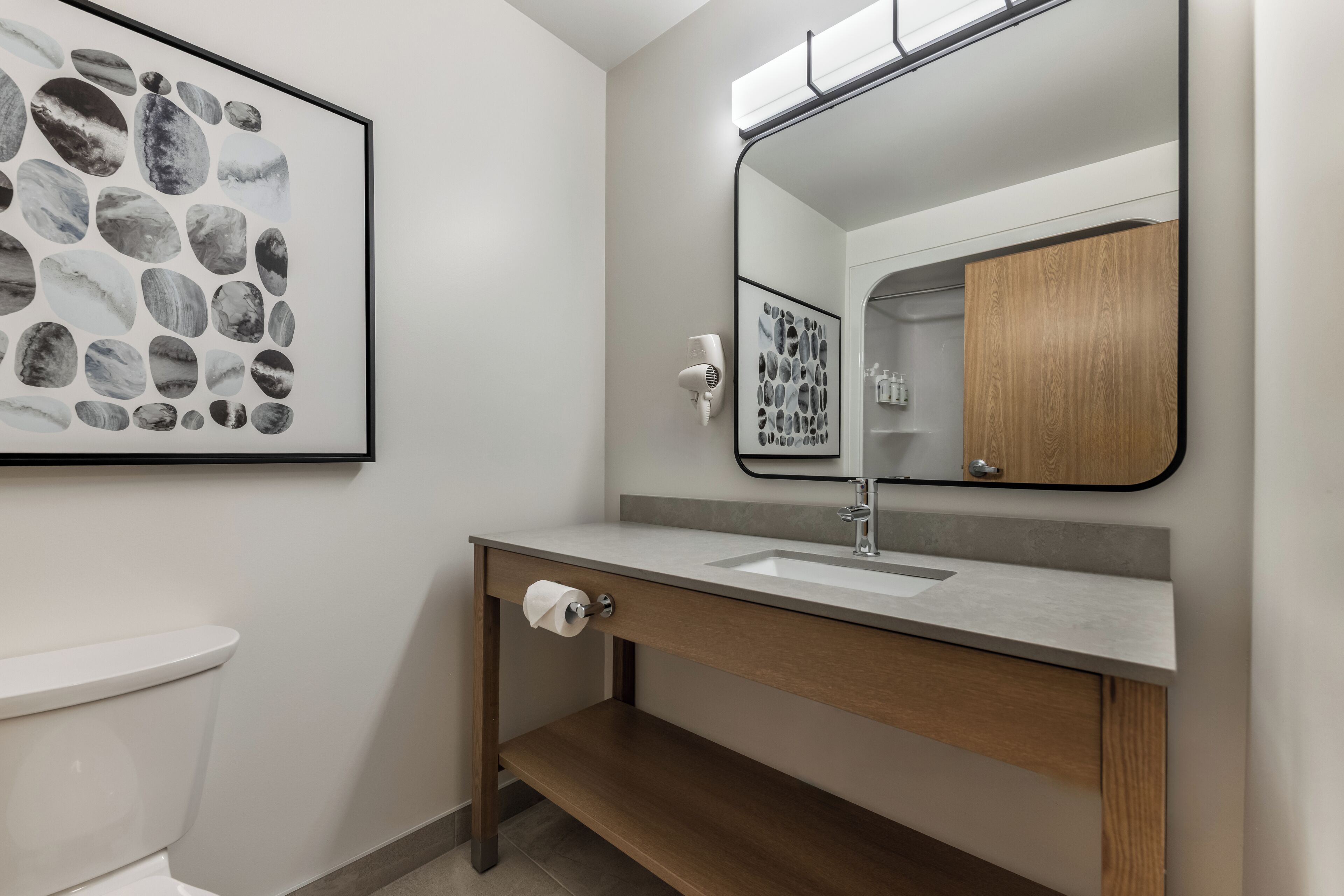 Une salle de bain moderne avec des toilettes, un lavabo et un miroir.