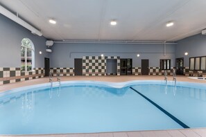 A swimming pool with a checkered wall pattern, a tiled floor, and a ceiling with recessed lighting. - Days Inn & Suites by Wyndham Thunder Bay (Thunder Bay)