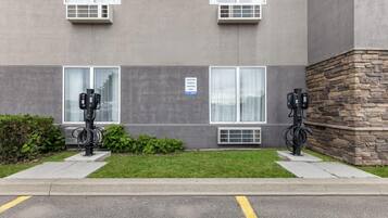 A building with two parking meters and a sign indicating electric vehicle parking only.