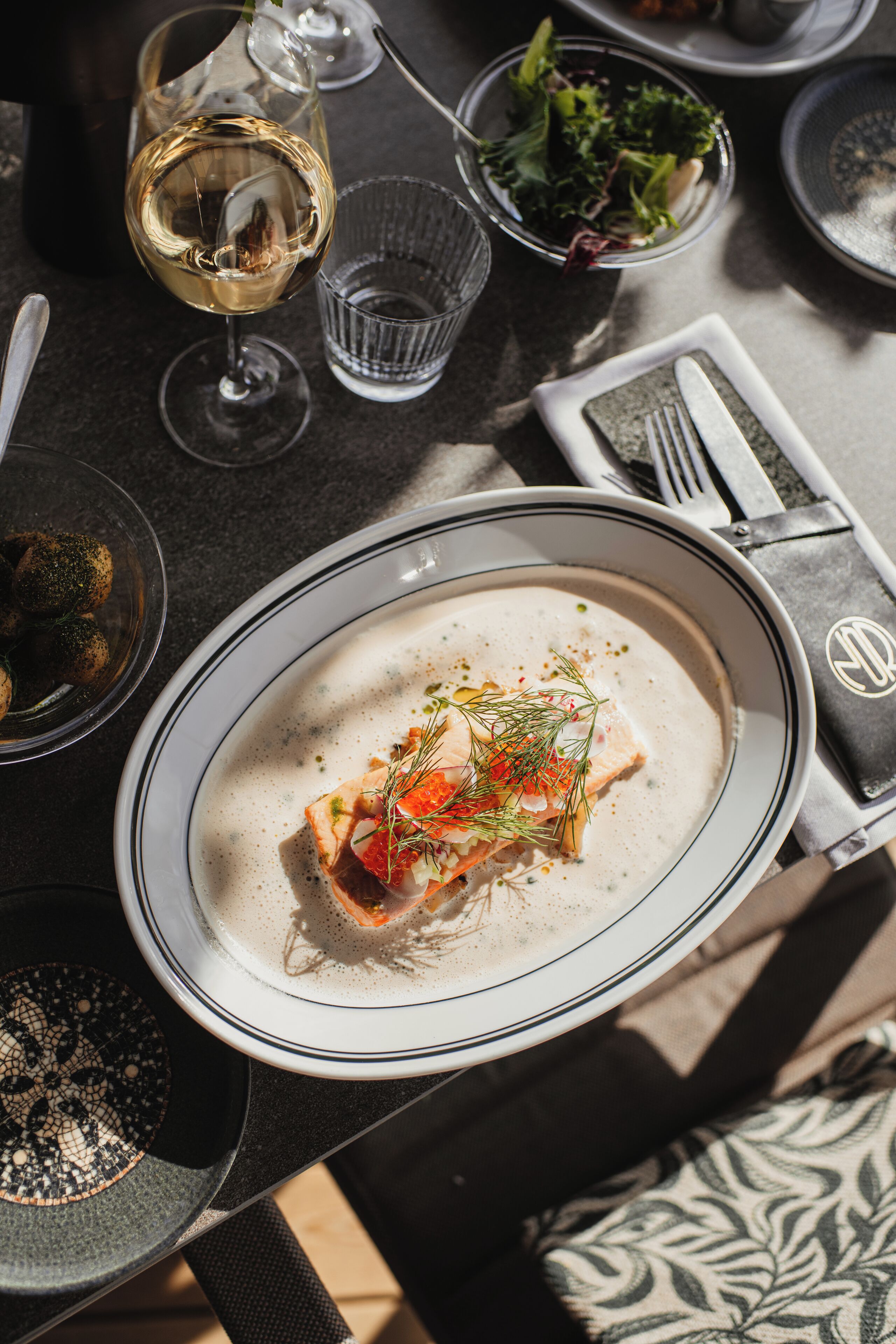 Una mesa de comedor dispuesta con platos, vasos y cubiertos.