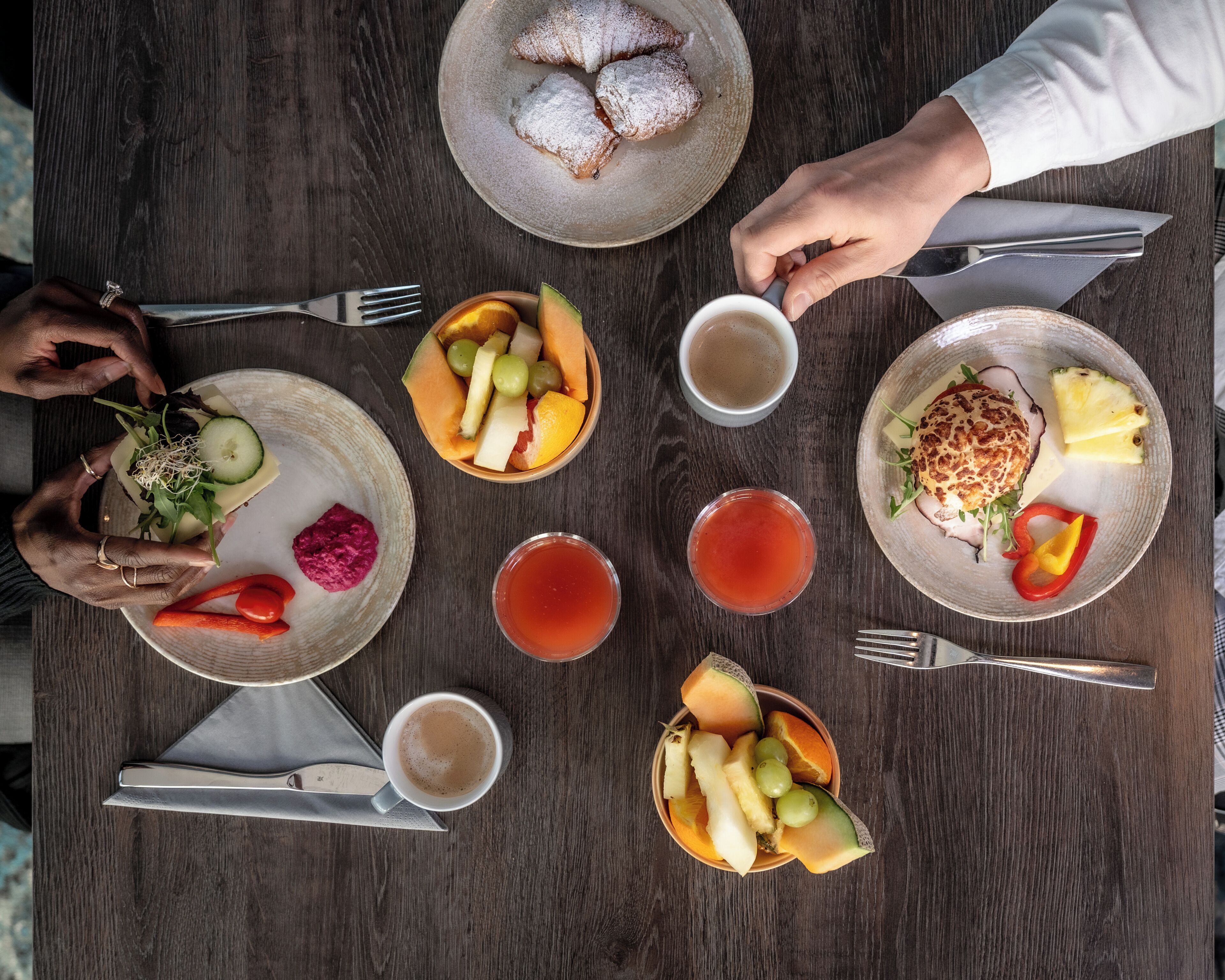 Une table garnie de différents plats, boissons et ustensiles.