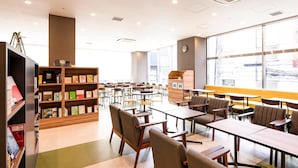 Une bibliothèque dotée d’étagères, de tables et de chaises, aménagée pour la lecture et le travail.