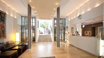 Relax in a welcoming space with a central staircase, comfortable seating areas, and a reception desk.