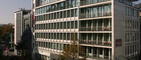 Un edificio moderno de varios pisos con ventanas y balcones amplios.