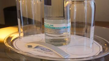 Distributore d'acqua in vetro con etichetta che indica acqua minerale media proveniente da FACHINGEN, Germania, con una capacità di 1,84 litri.