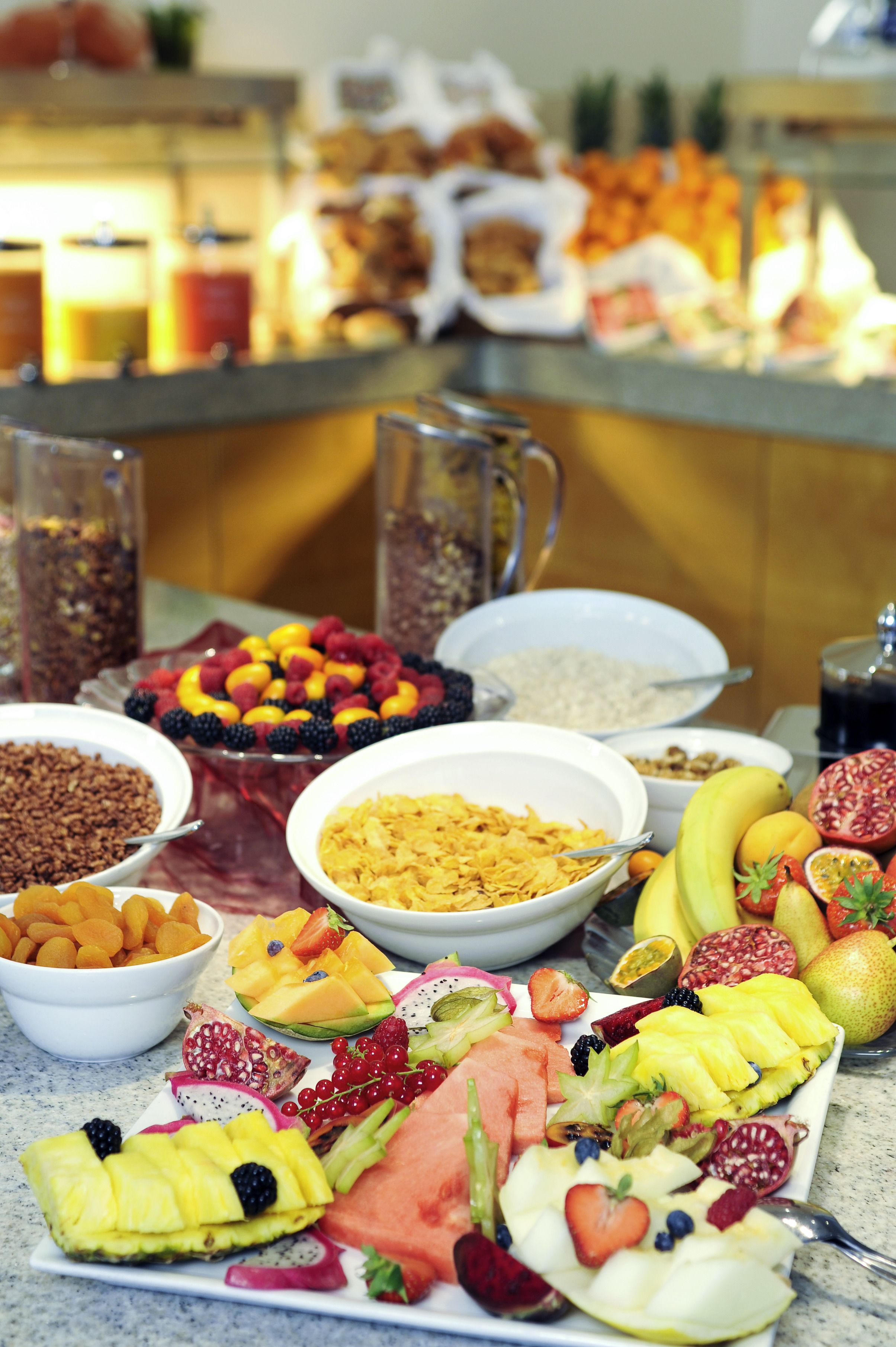 A buffet with various fruits, vegetables, and cereals.