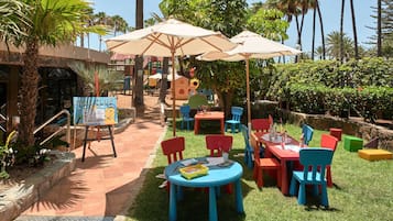 Relax in a lush outdoor space surrounded by palm trees and tropical plants, perfect for casual dining or meetings.