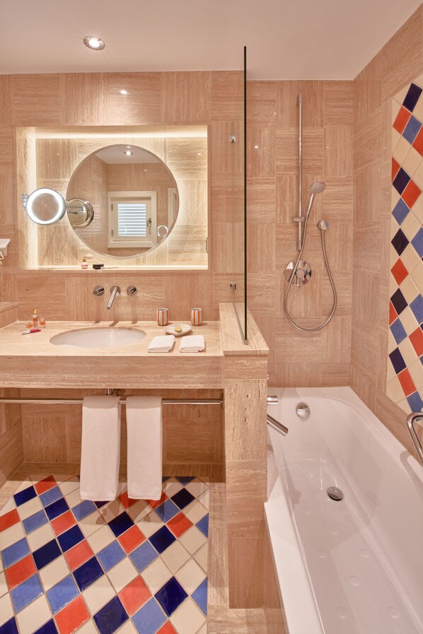 A modern bathroom with a large sink, mirror, and shower.