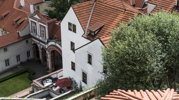 Un edificio blanco con techo de tejas rojas, rodeado de otros edificios con techos similares.