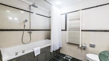 Et moderne badeværelse med badekar, bruser og toilet.
