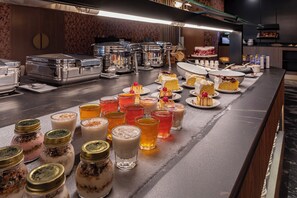 A buffet with various food items and beverages.