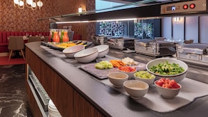 A buffet with various food items and bowls.
