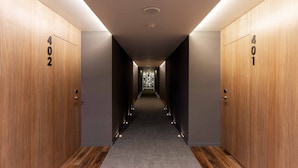 A hallway with wooden doors labeled 402 and 401, leading to a patterned wall at the end.