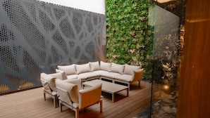 A modern outdoor seating area with a sectional sofa and a coffee table.