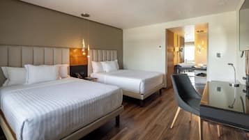 Habitación de hotel con dos camas, un escritorio y una silla.