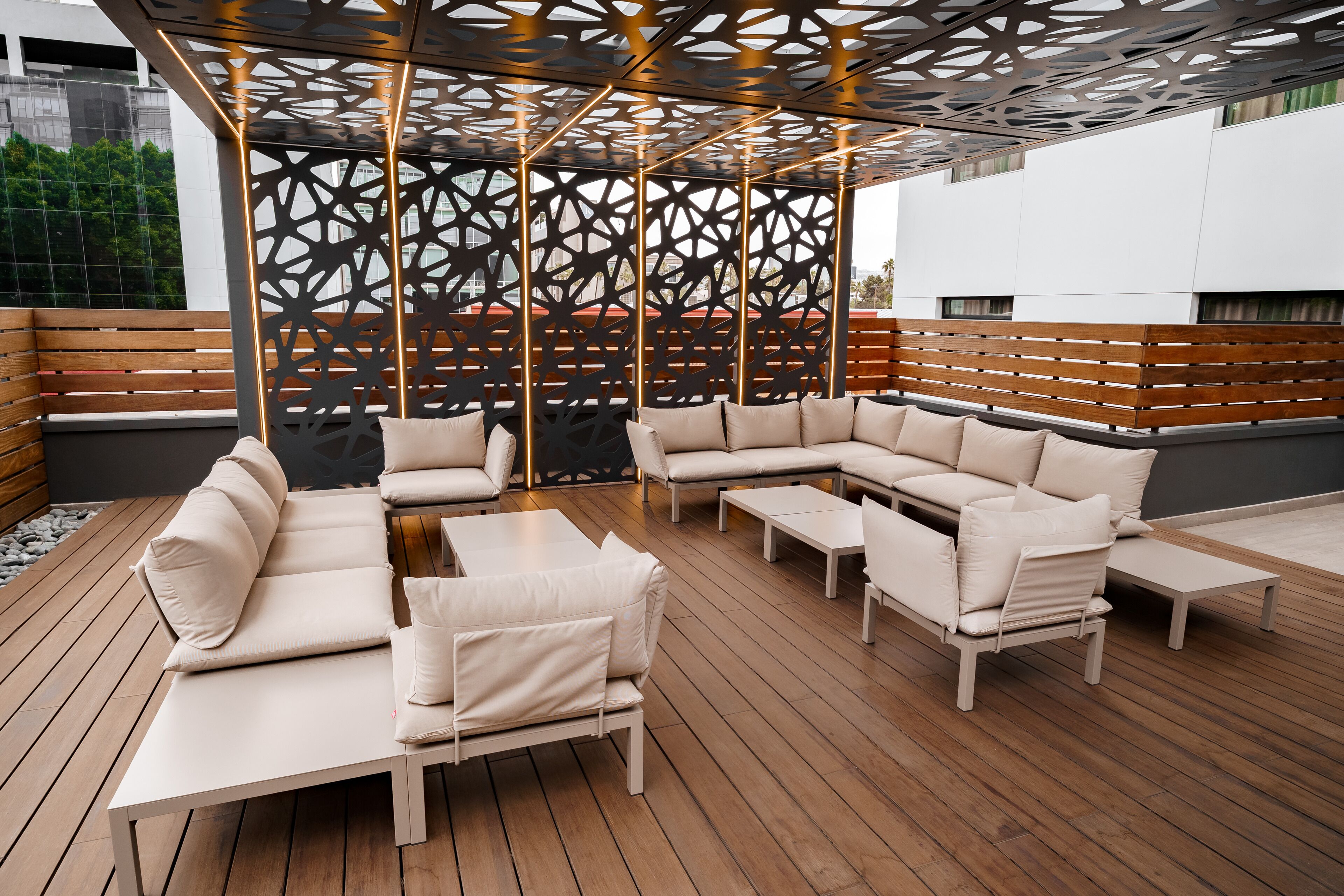 An outdoor seating area with a modern design, featuring a sectional sofa and a coffee table.