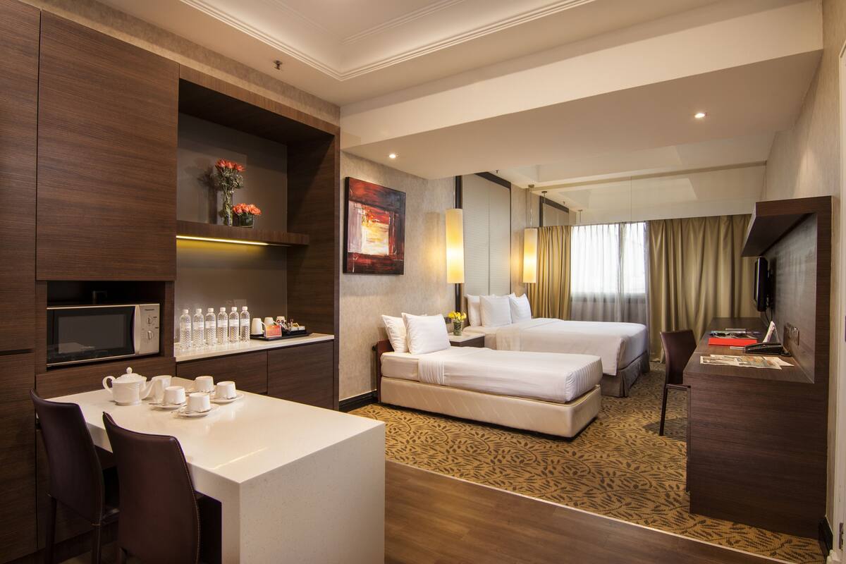 Ein Hotelzimmer mit Bett, Schreibtisch, Mikrowelle, einer Kaffeestation und einem Fernseher.