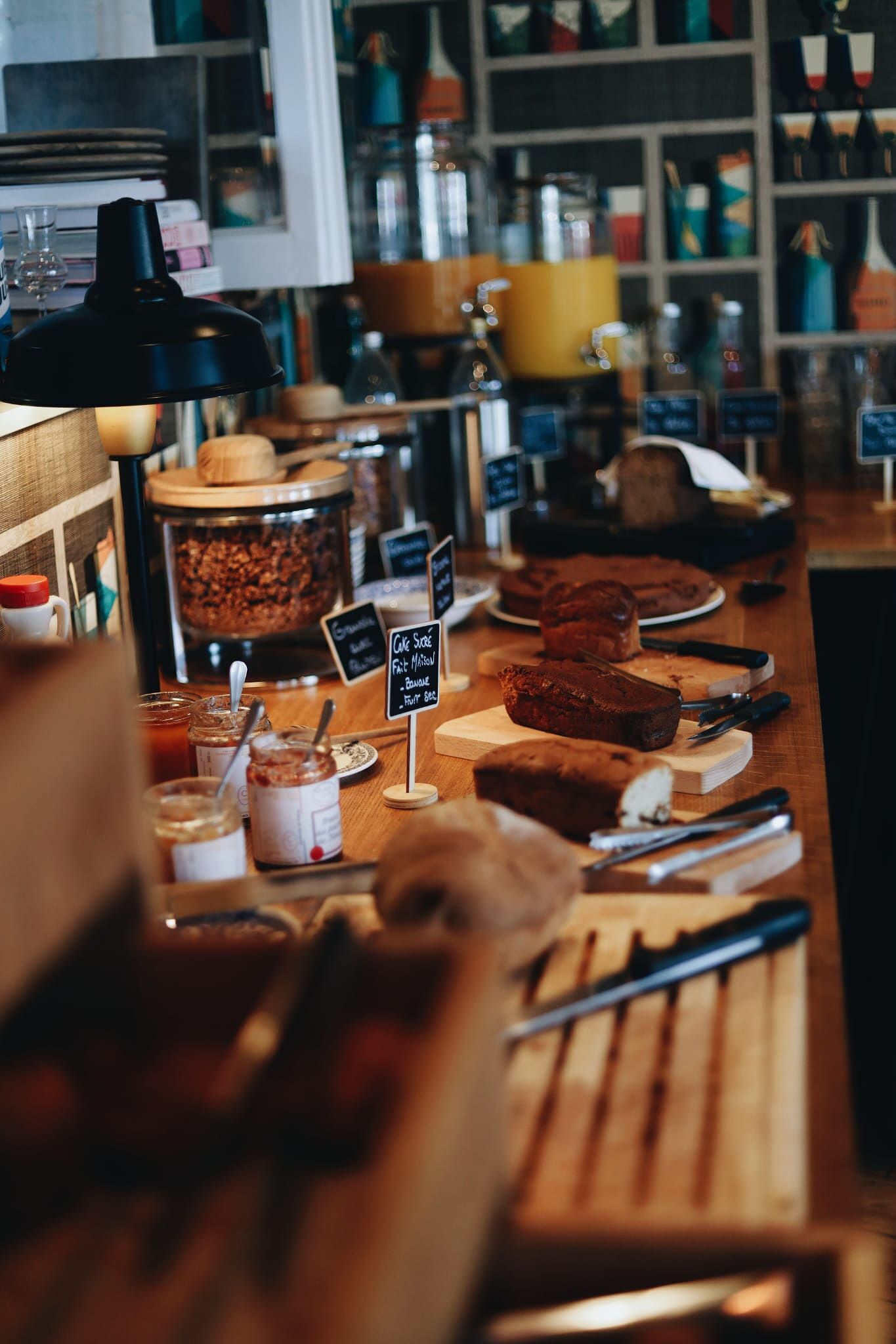 A bakery counter with various baked goods and jars of spreads.