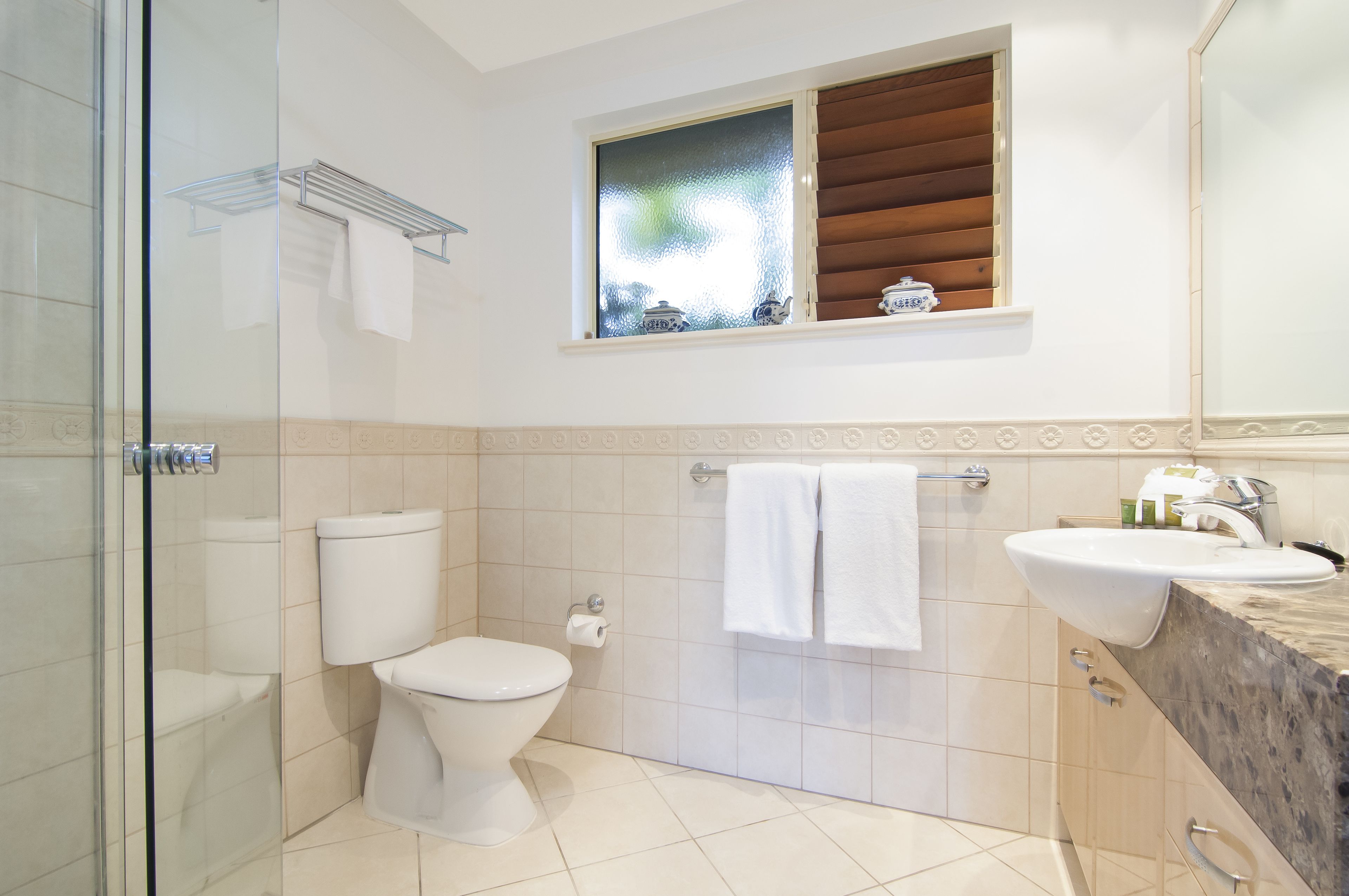 Un baño moderno con inodoro, lavamanos y ducha.