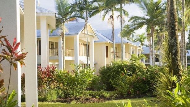 A resort with multiple-story buildings, palm trees, and a well-maintained garden. - Paradise Links Resort Port Douglas (Craiglie)