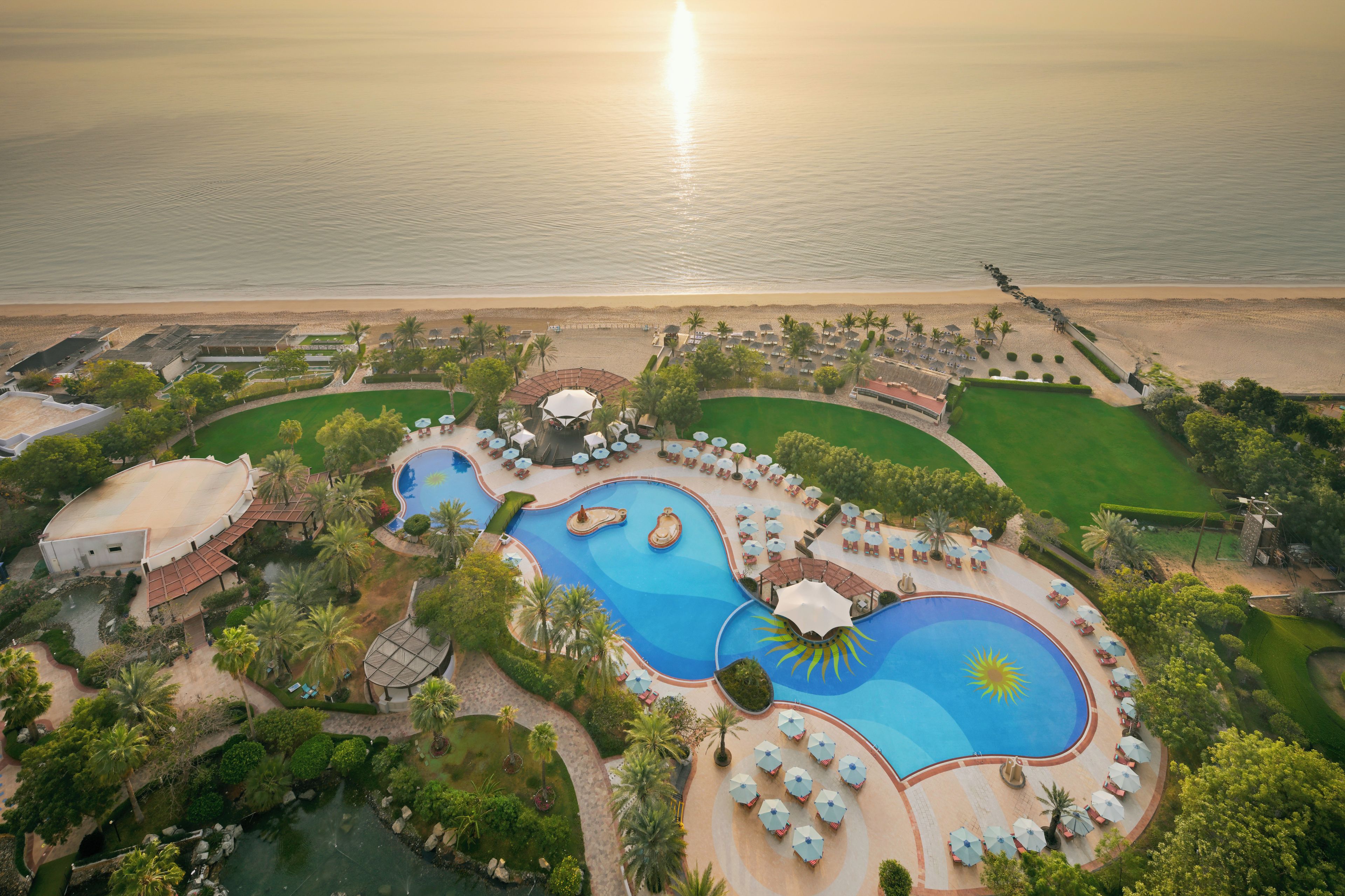 A resort with multiple swimming pools, a beach, and a golf course.